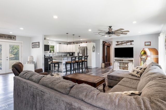 living area with a ceiling fan, recessed lighting, french doors, and wood finished floors