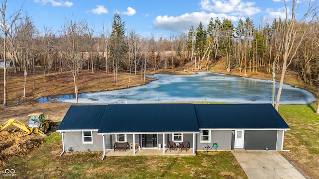 view of front of property with a patio area, metal roof, and a front lawn