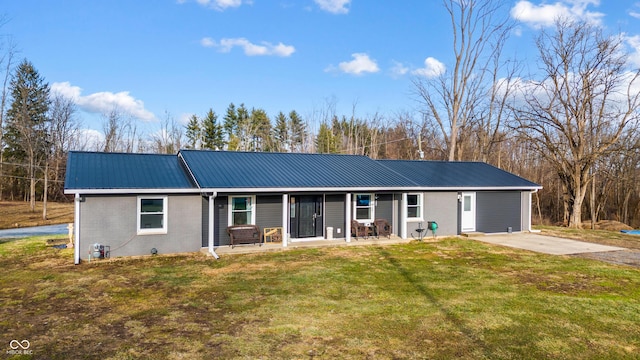 ranch-style house featuring driveway, a front lawn, metal roof, and brick siding