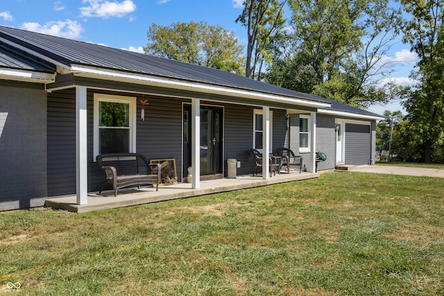 view of front of house featuring a porch, brick siding, metal roof, and a front lawn