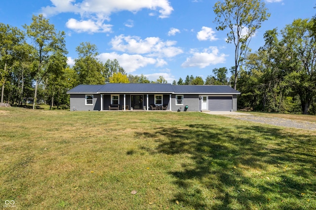 ranch-style house featuring driveway, metal roof, a garage, and a front lawn