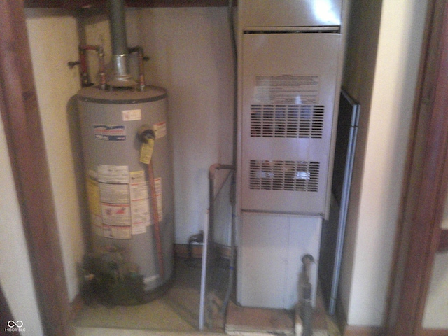 utility room featuring gas water heater and heating unit