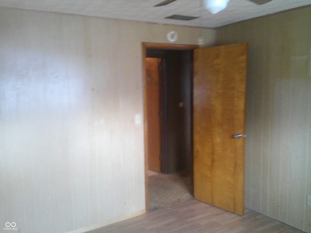 empty room featuring ceiling fan, visible vents, and light wood-style floors