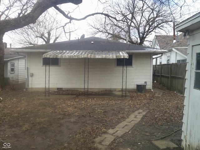 back of property featuring crawl space and fence