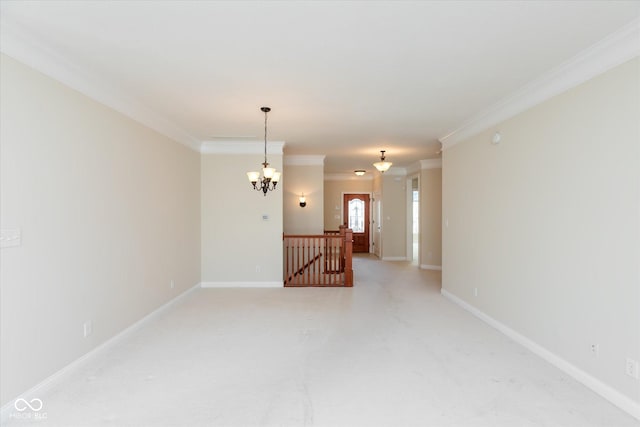 empty room featuring a chandelier, ornamental molding, and baseboards