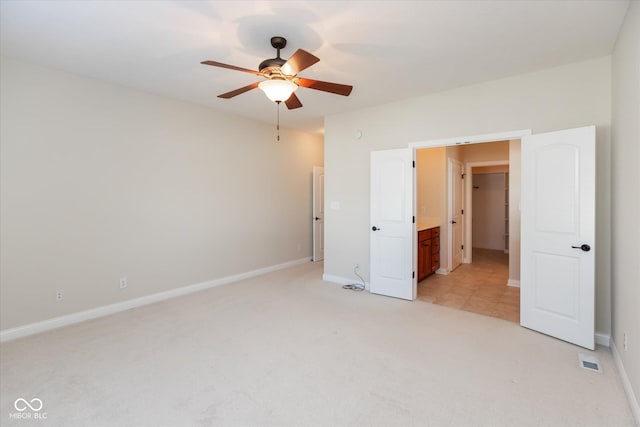 unfurnished bedroom featuring a ceiling fan, light carpet, and baseboards