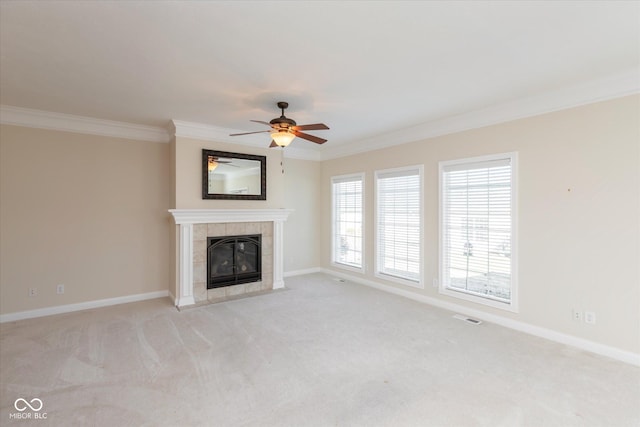 unfurnished living room featuring ornamental molding, a tile fireplace, light carpet, and baseboards