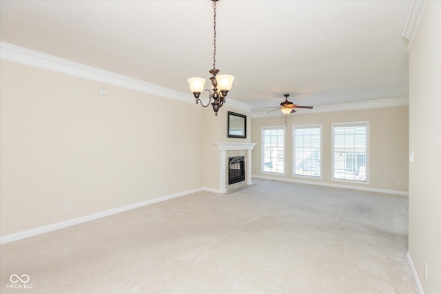 unfurnished living room featuring light carpet, ceiling fan with notable chandelier, a fireplace with flush hearth, baseboards, and crown molding