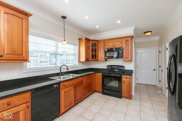 kitchen featuring dark countertops, brown cabinets, a sink, and black appliances