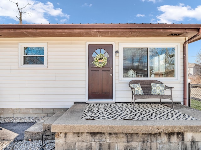 property entrance with visible vents and fence