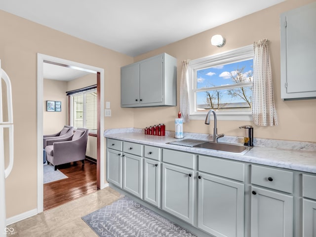 kitchen with gray cabinets, light countertops, and a sink