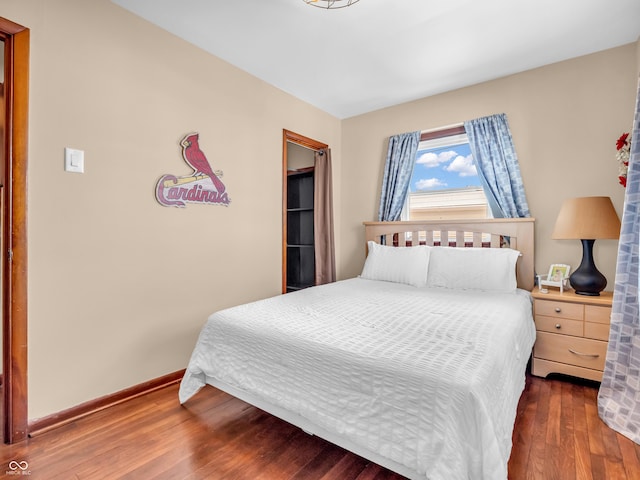 bedroom featuring hardwood / wood-style floors and baseboards