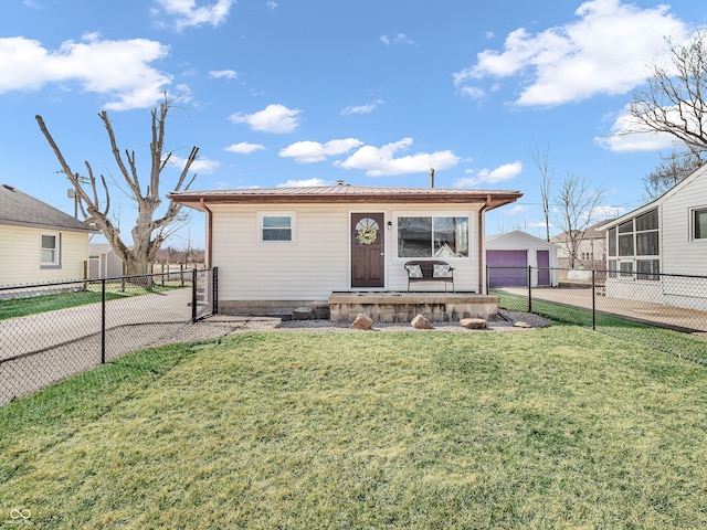 bungalow featuring a front lawn, a detached garage, and a fenced backyard