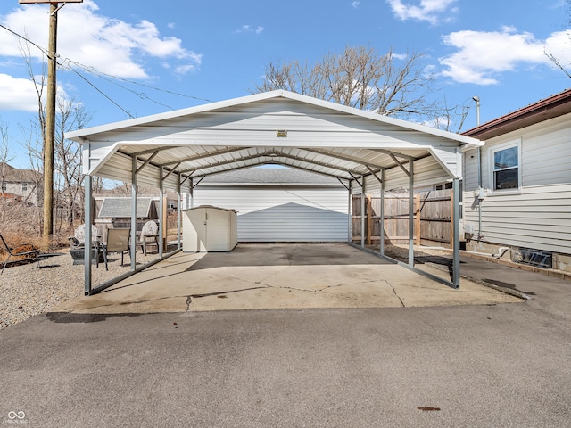 view of vehicle parking with fence and a detached carport