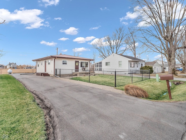 view of front of house featuring entry steps, a fenced front yard, and a front yard