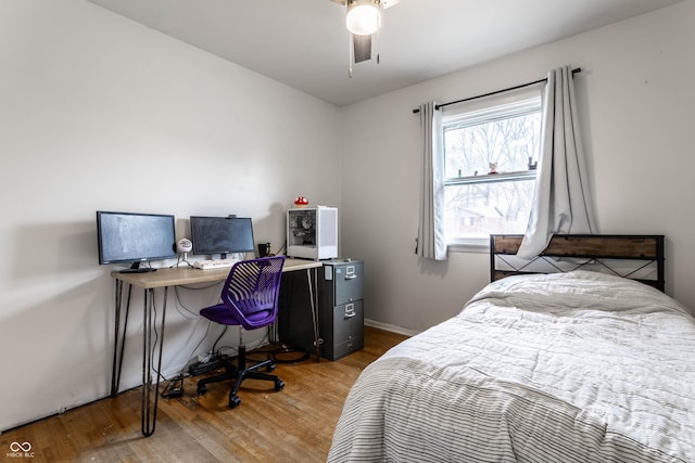 bedroom with ceiling fan, baseboards, and wood finished floors