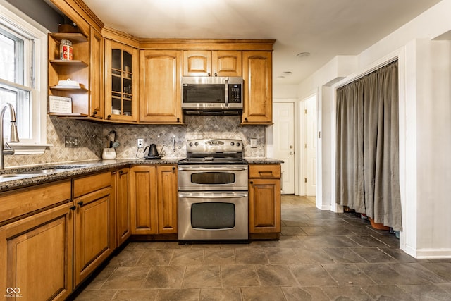 kitchen featuring brown cabinets, stainless steel appliances, and a sink