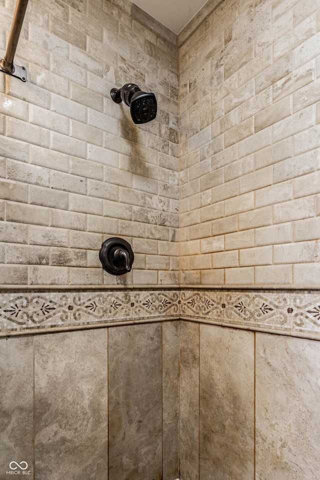 interior details featuring a tile shower