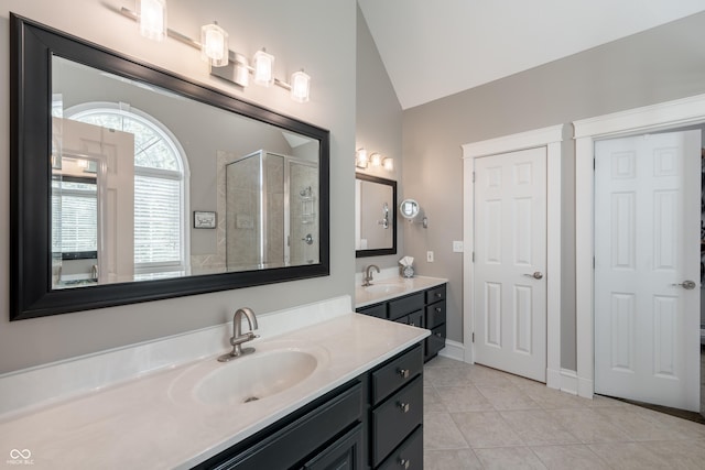 full bath with vanity, baseboards, a shower stall, vaulted ceiling, and tile patterned floors