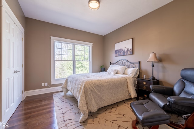 bedroom featuring baseboards and dark wood-style flooring