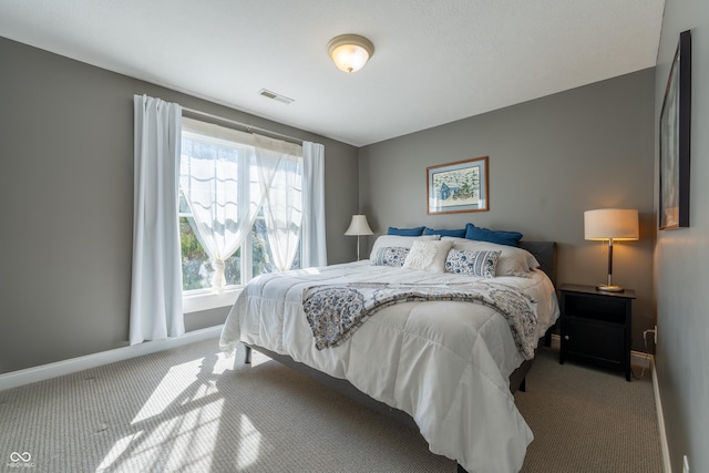 carpeted bedroom featuring visible vents and baseboards