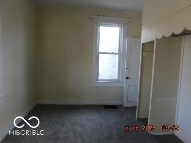 spare room featuring carpet floors and baseboards