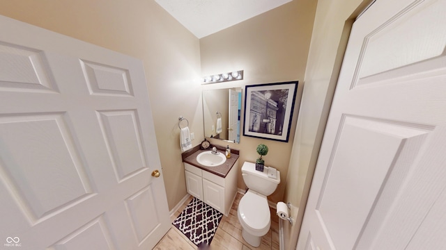 bathroom featuring baseboards, toilet, and vanity