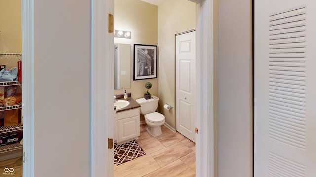 bathroom featuring a closet, toilet, and vanity