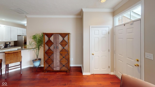 foyer entrance featuring dark wood finished floors, visible vents, baseboards, and ornamental molding