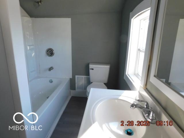 bathroom featuring toilet, visible vents, shower / bathing tub combination, and vanity