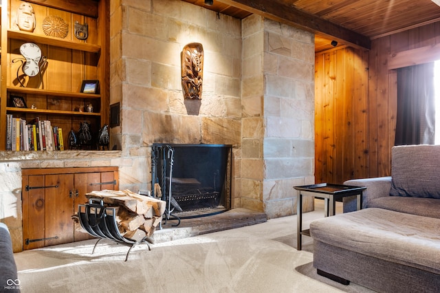 living room with beamed ceiling, built in shelves, wood ceiling, and carpet floors