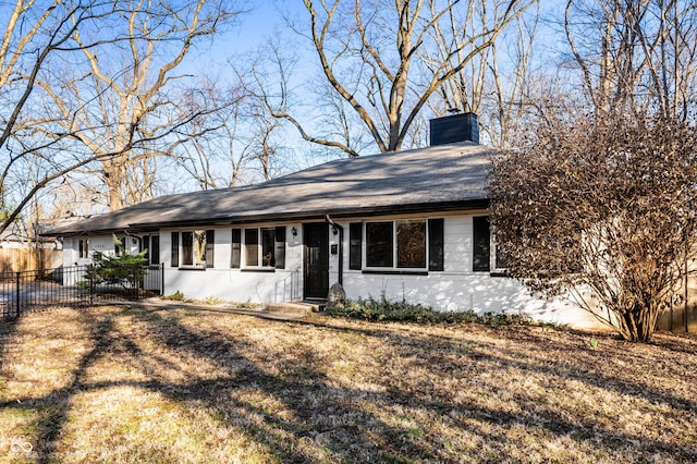 single story home with concrete block siding, a chimney, roof with shingles, and fence