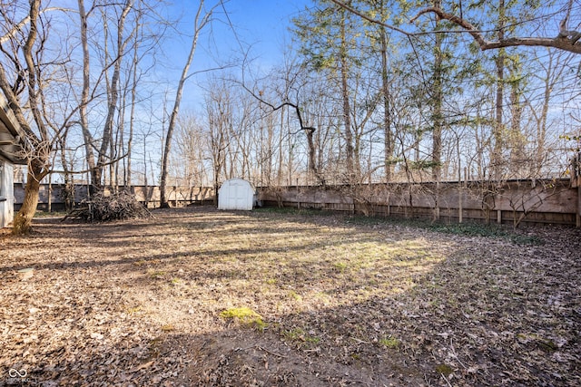 view of yard featuring a fenced backyard, a storage unit, and an outdoor structure