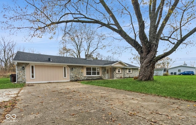 ranch-style house featuring stone siding, a chimney, concrete driveway, and a front yard