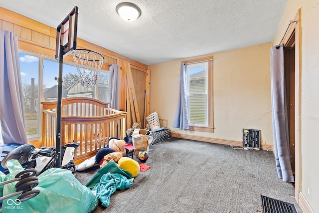 bedroom featuring carpet floors, visible vents, a textured ceiling, and baseboards