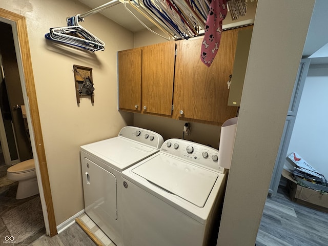 laundry room with washer and dryer, cabinet space, and light wood-style flooring