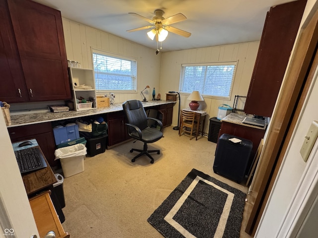 office with light carpet, plenty of natural light, wooden walls, and ceiling fan