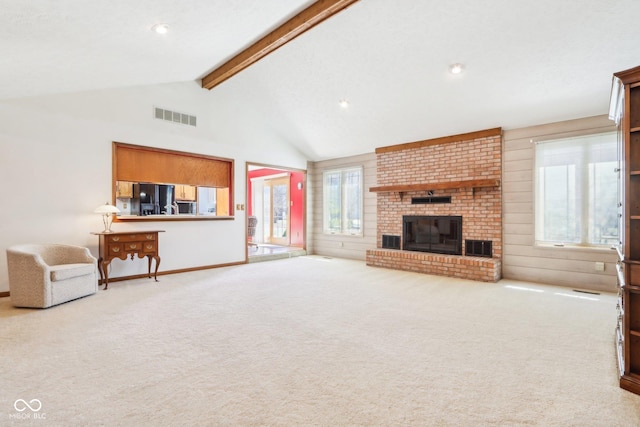 unfurnished living room with visible vents, beam ceiling, carpet, and a brick fireplace