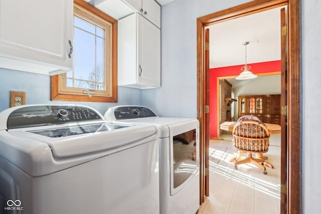 laundry room with cabinet space, light floors, and washing machine and dryer