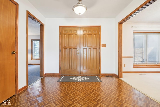 entryway with visible vents, a healthy amount of sunlight, and baseboards