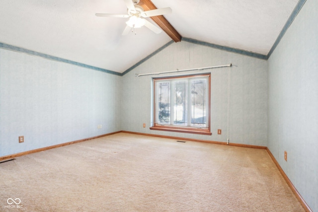 spare room with visible vents, baseboards, carpet, lofted ceiling with beams, and a ceiling fan