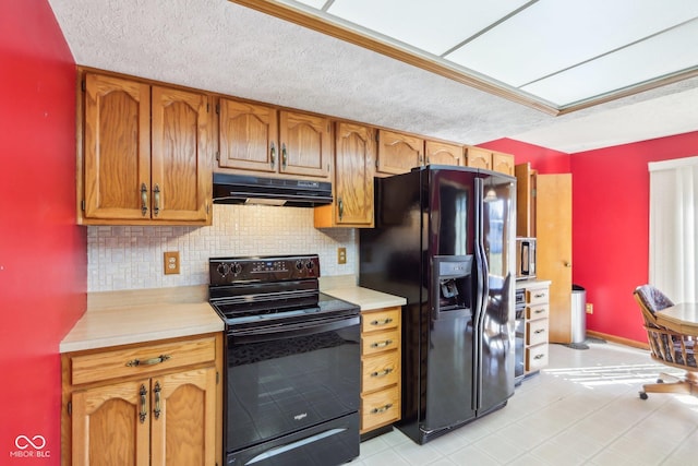 kitchen featuring black appliances, backsplash, light countertops, and under cabinet range hood