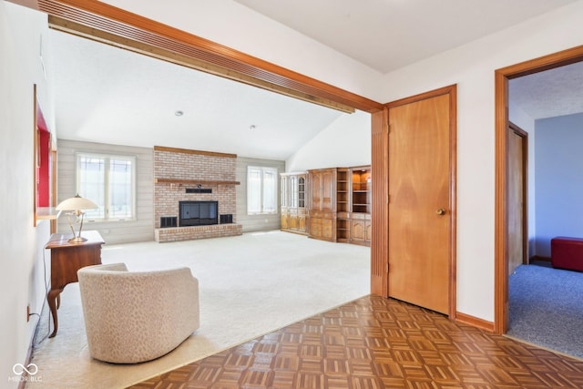 carpeted living room featuring baseboards, lofted ceiling, and a brick fireplace