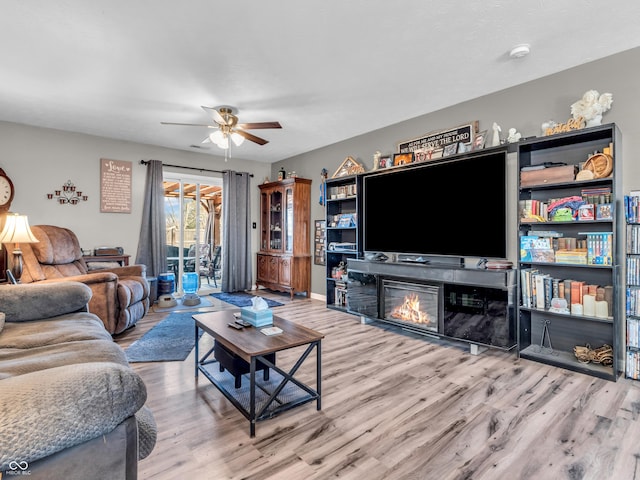 living room with baseboards, a ceiling fan, and wood finished floors