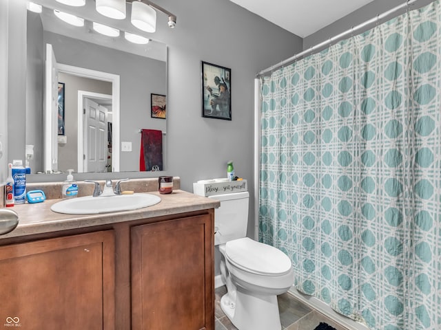 bathroom featuring toilet, vanity, and a shower with curtain