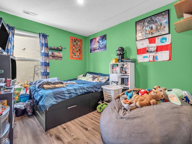 bedroom with visible vents and wood finished floors