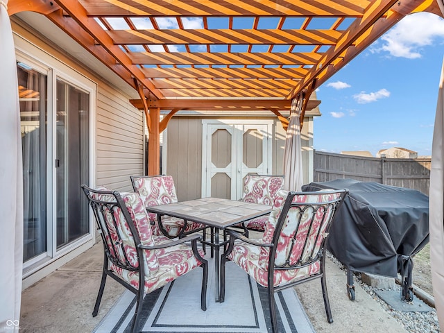 view of patio featuring fence, a pergola, an outdoor structure, outdoor dining space, and a storage unit