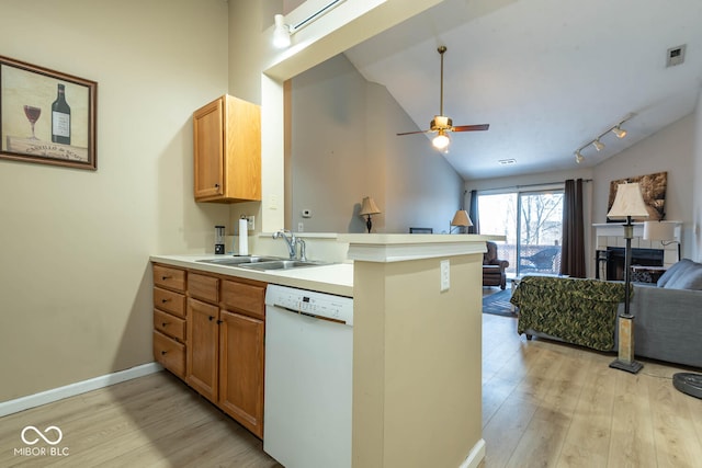 kitchen with light wood-style flooring, a sink, open floor plan, a peninsula, and white dishwasher