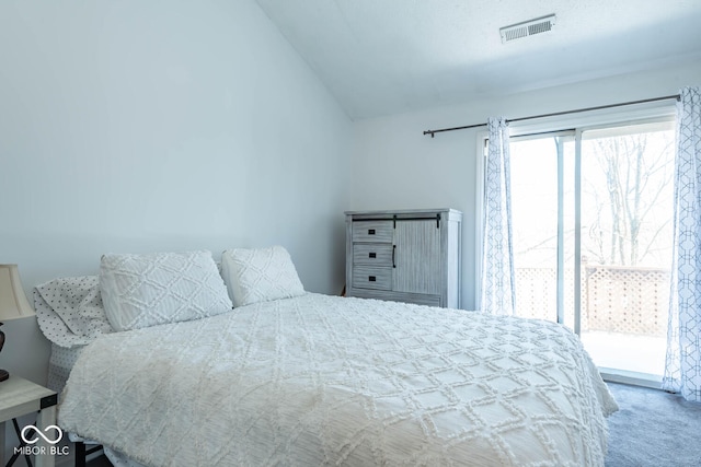 carpeted bedroom featuring visible vents and vaulted ceiling