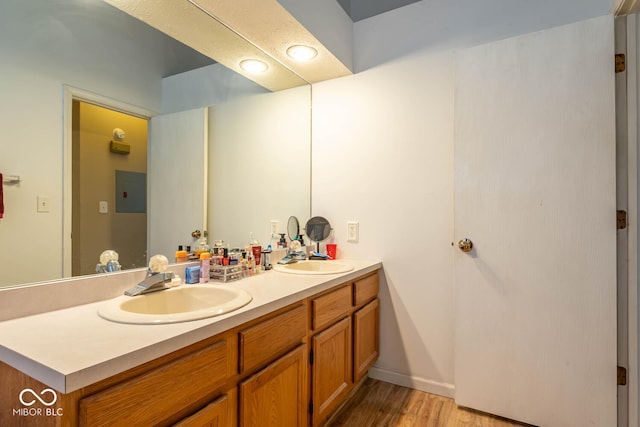 bathroom featuring a sink, wood finished floors, and double vanity